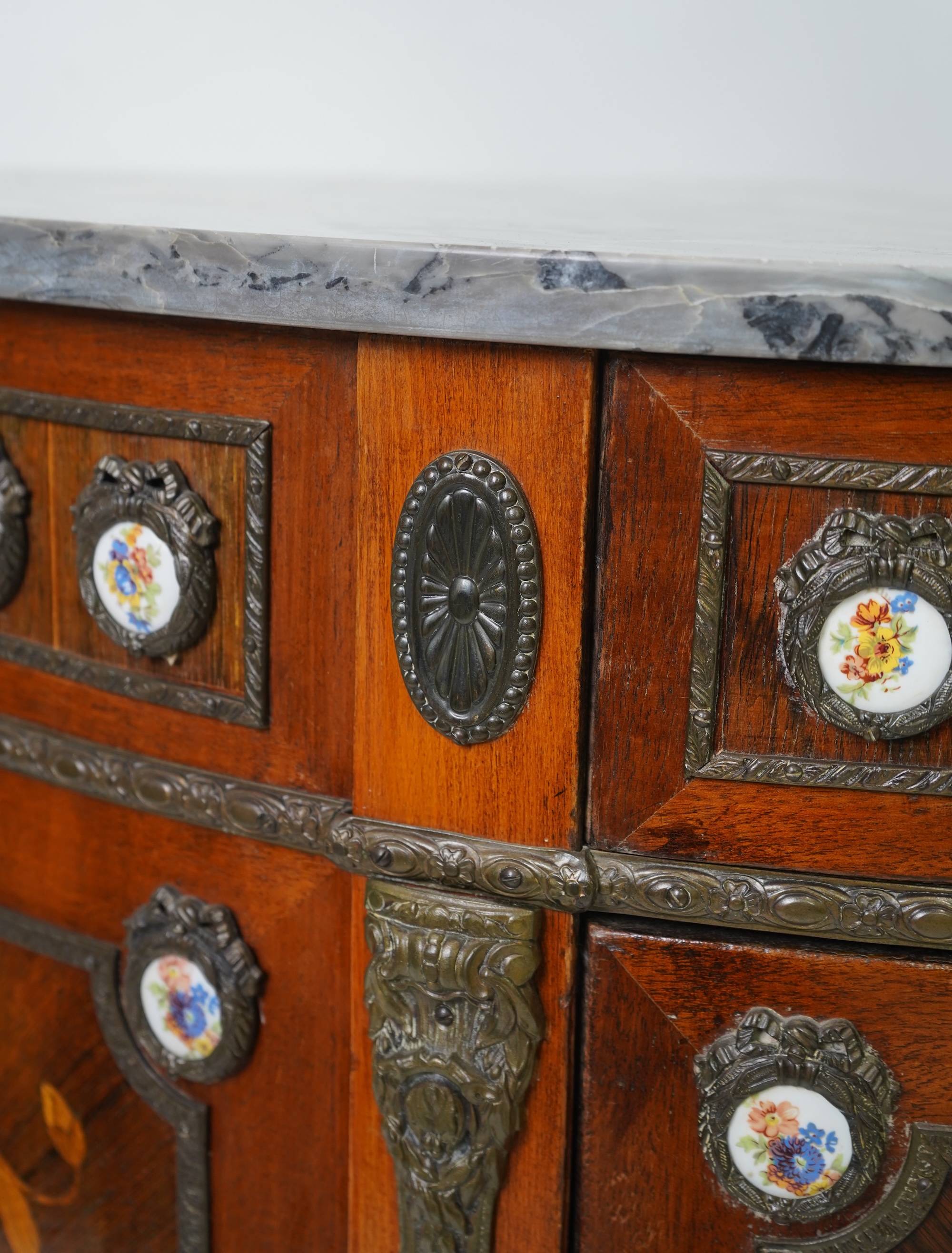 A pair of early 20th century French marquetry inlaid, gilt metal and porcelain mounted rosewood and beech demi-lune commodes